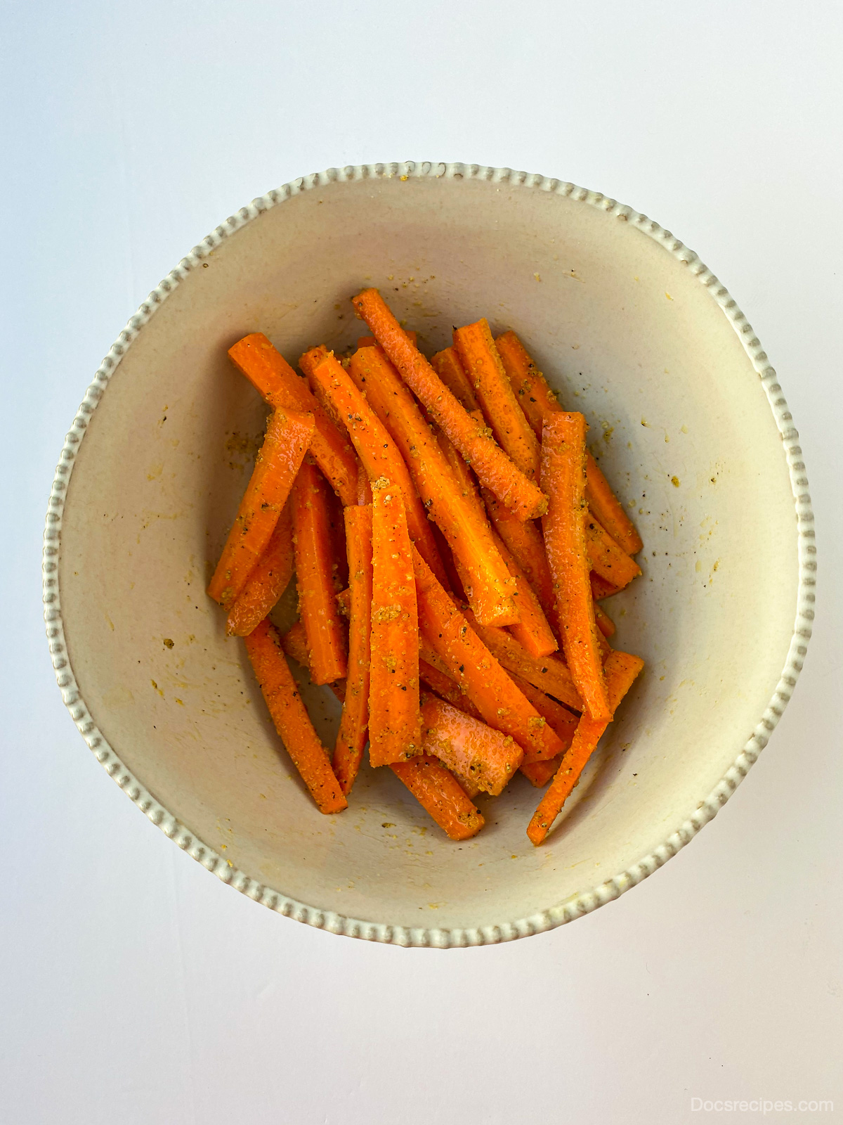 Overhead image of Air Fryer Carrot Fries uncooked with seasoning mixed in