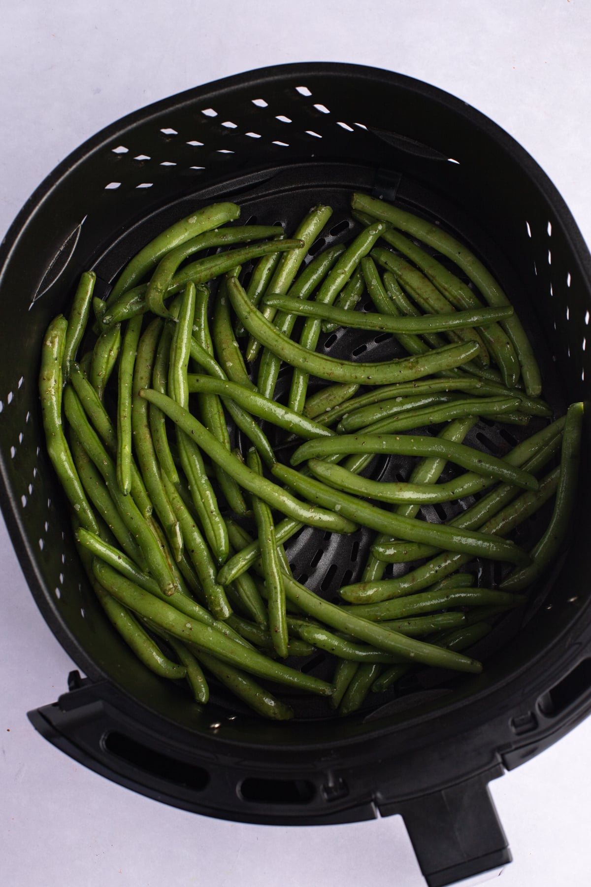 green beans in the basket of an air fryer