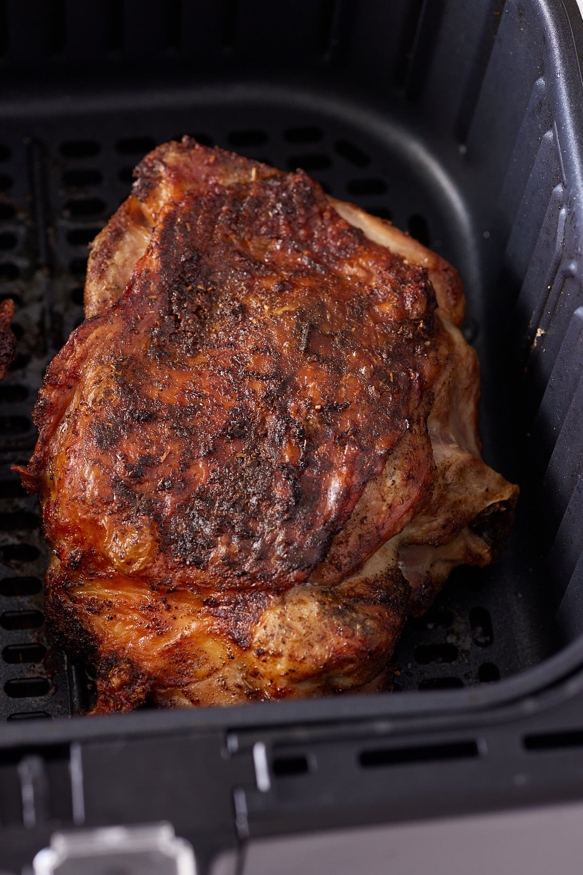 close up of turkey thigh cooked through in air fryer basket