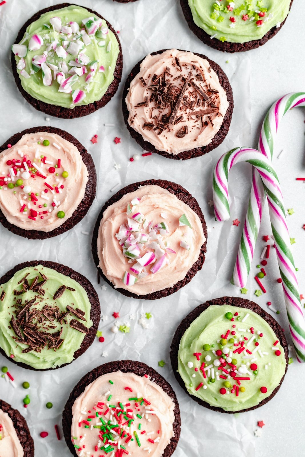 chocolate mint cookies with mint frosting next to candy canes