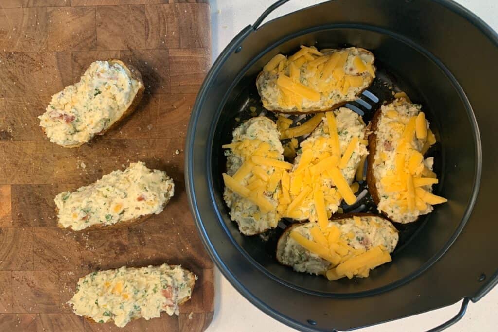 filled potatoes back in the air fryer topped with cheddar