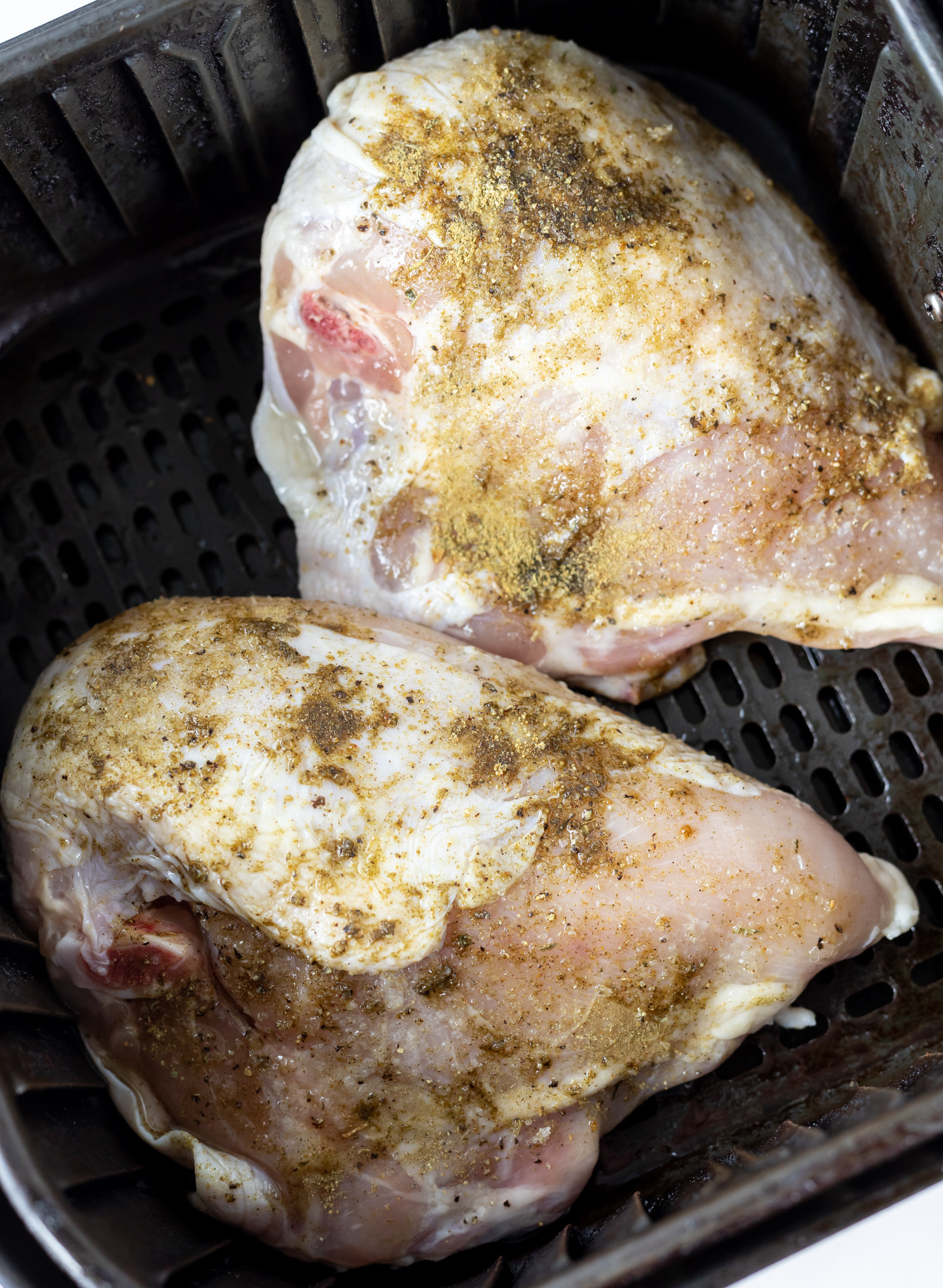 raw chicken breasts in air fryer basket