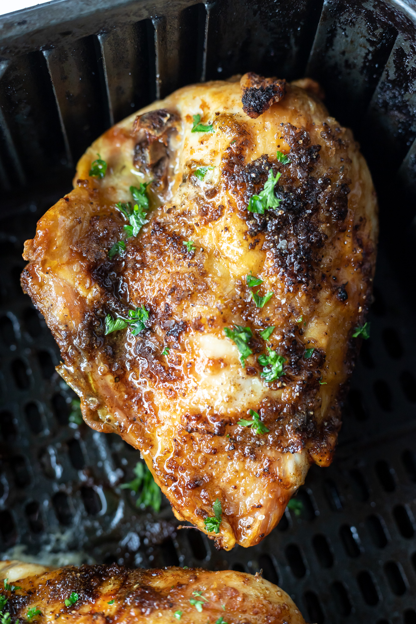 cooked split chicken breast in air fryer basket