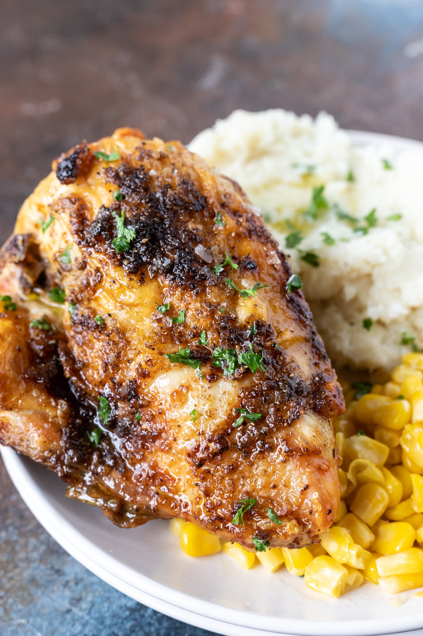 cooked chicken breast on plate with mashed potatoes and corn