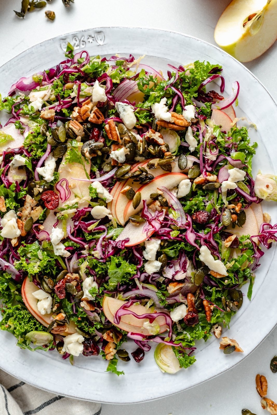 kale apple salad with nuts and gorgonzola on a plate