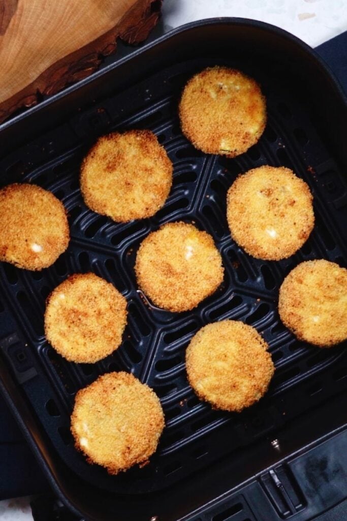 Close up of cooked zucchini chips in air fryer basket