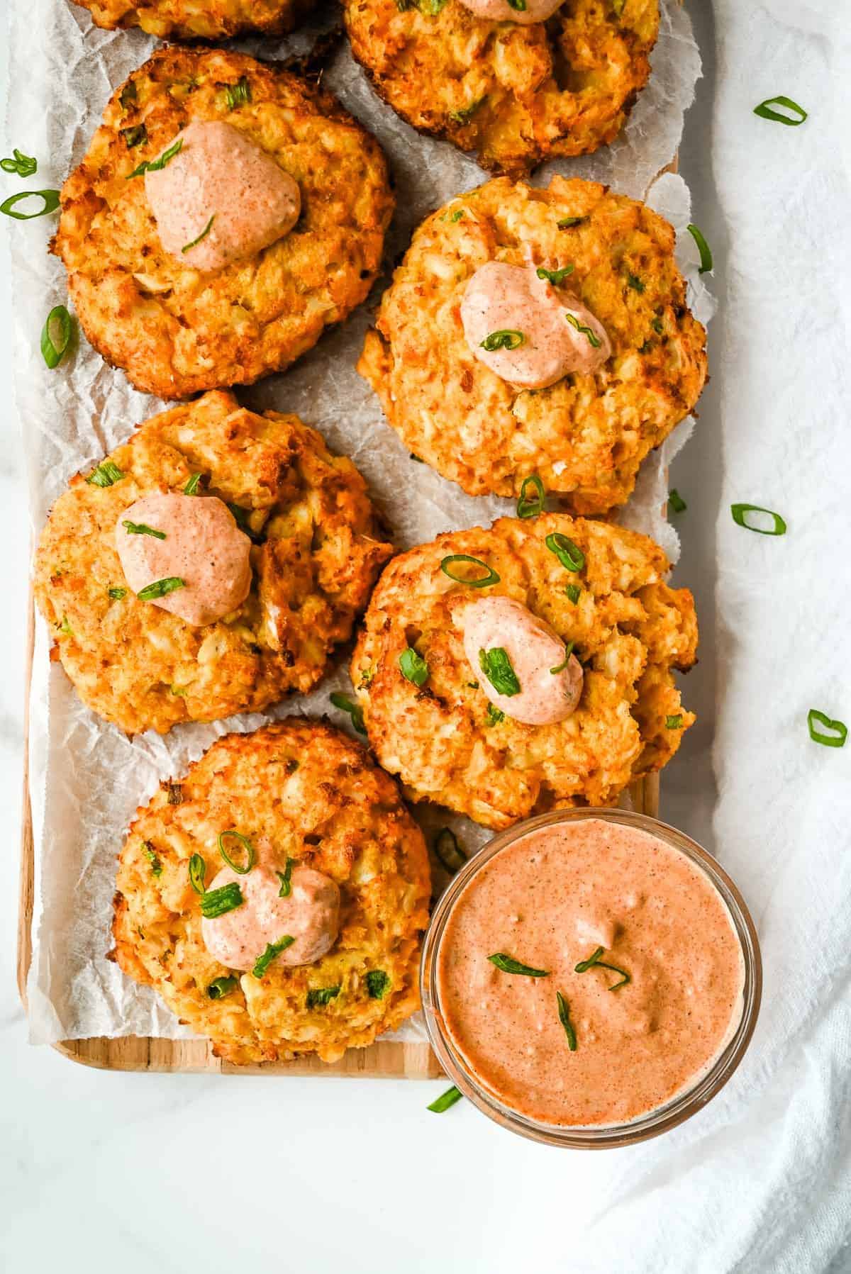 tray of air fried crab cakes with remoulade and topped with green onions.