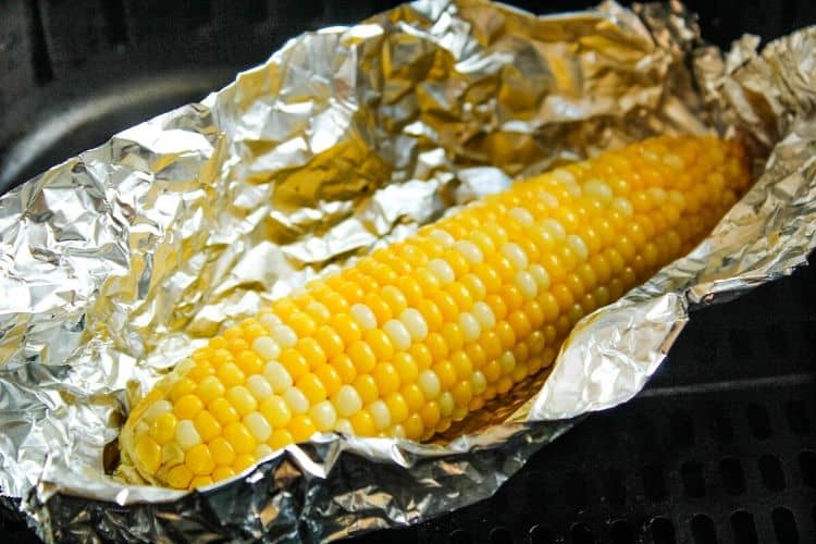 Cooked air fryer corn on the cob in foil opened up