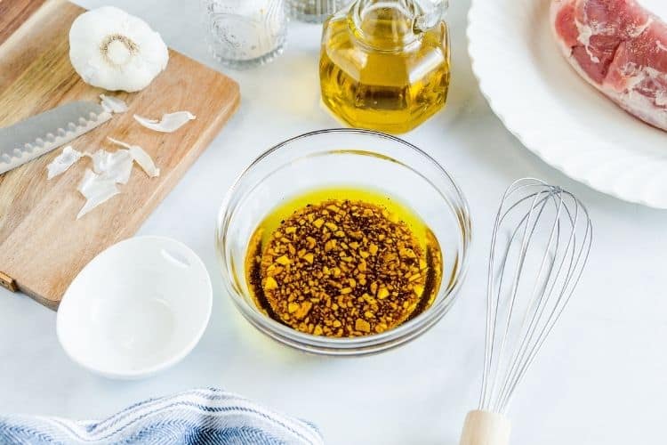 Marinade ingredients mixed in a bowl with a whisk to the side