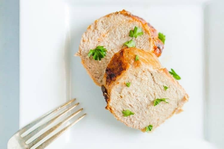 Closeup of air fryer pork tenderloin medallions on a white plate