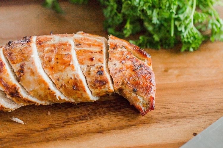 Closeup of sliced air fried pork tenderloin on a cutting board