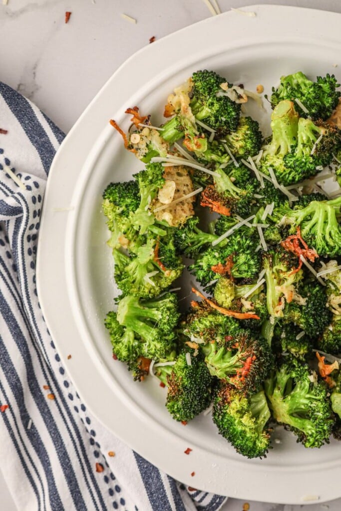 air fryer broccoli on a white circular plate